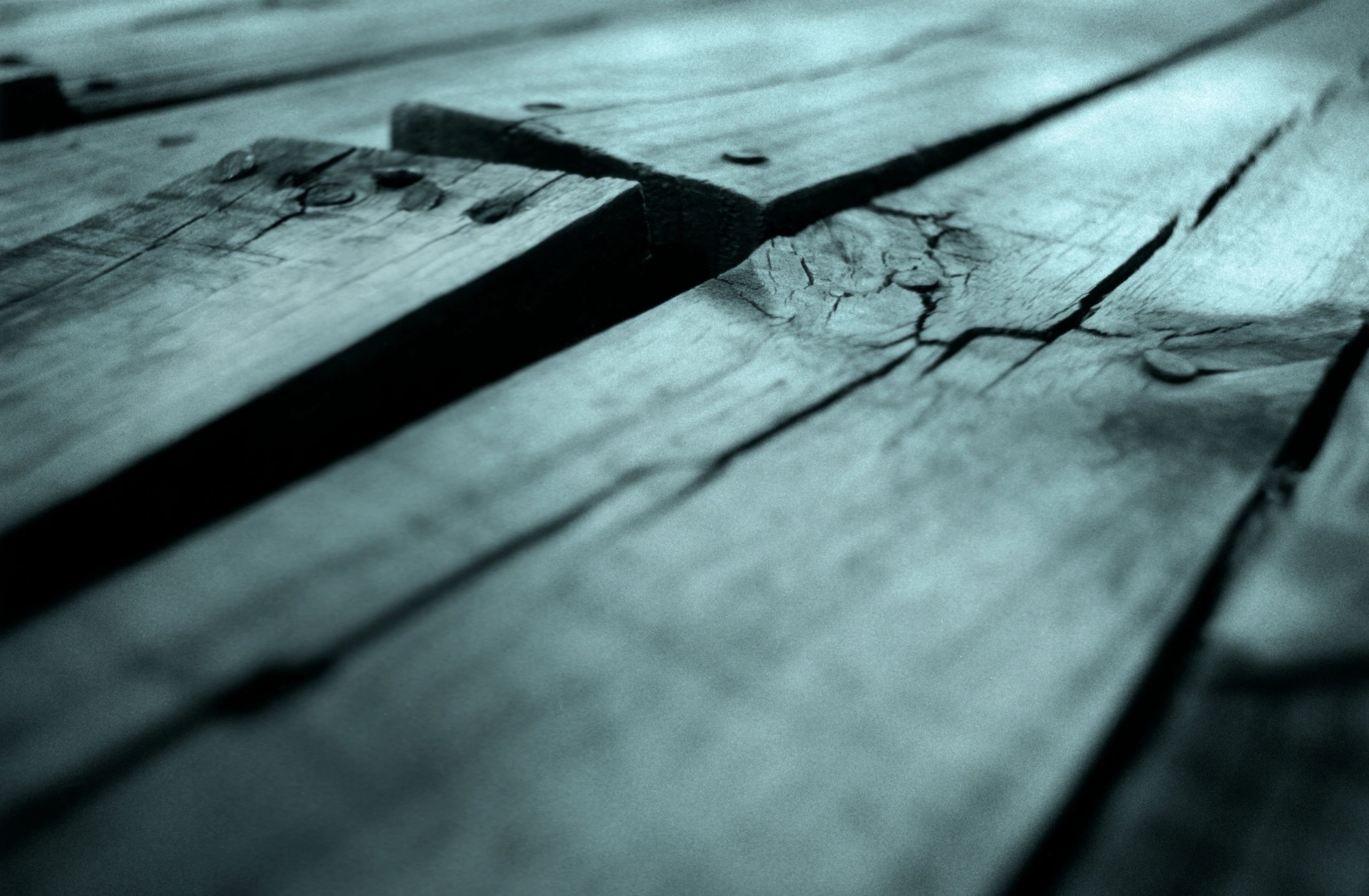 Close-up of damaged, lifting deck boards before repair